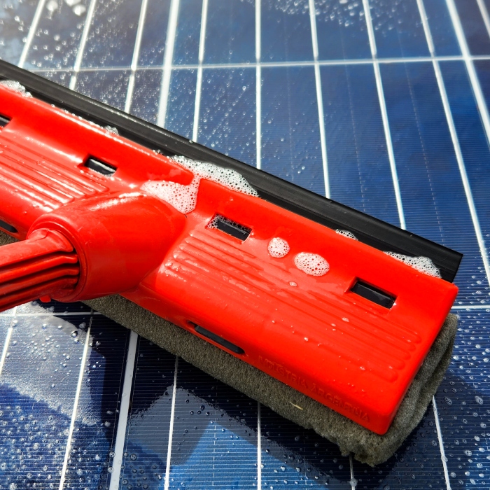 Nettoyage de panneau solaire avec raclette professionnelle pour préserver son rendement